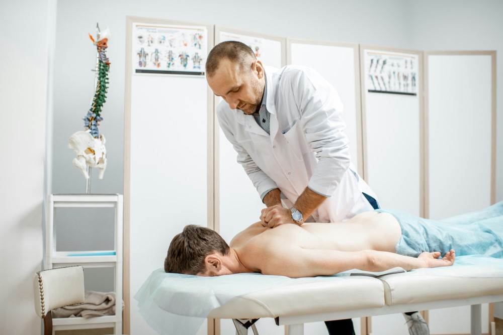 Présentation d'un chiropracteur faisant une technique à un patient pour soulager ses douleurs du rachis suite à un coup du lapin