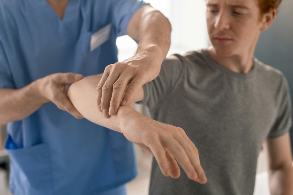 Présentation d'un jeune homme se faisant manipuler par un rhumatologue pour l'arthrite psoriasique