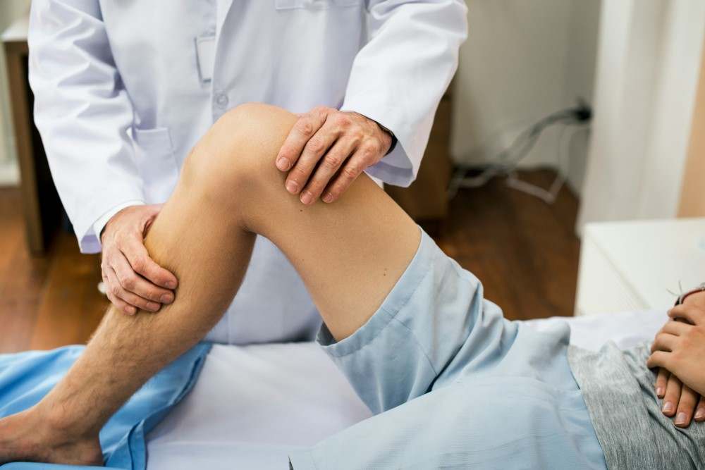 Présentation d'une photo d'un adolescent se faisant manipuler pour des douleurs au genou pour osgood schlatter