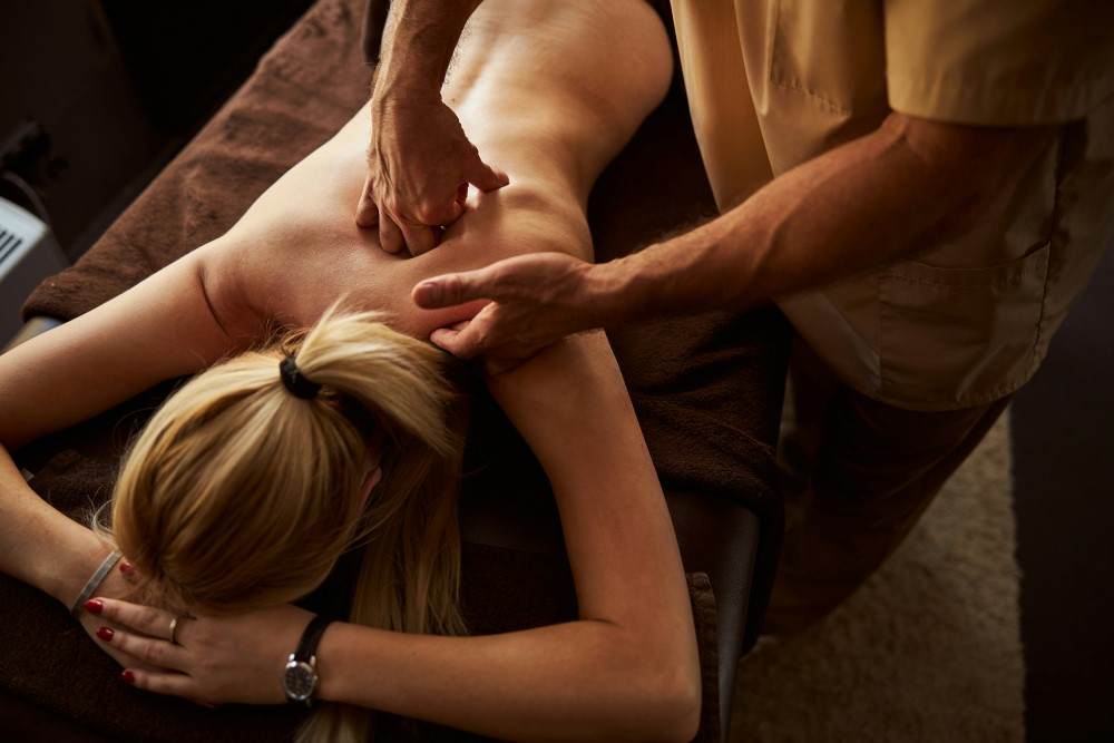 Présentation d'une femme se faisant manipuler par un chiropracteur pour douleur à l'omoplate