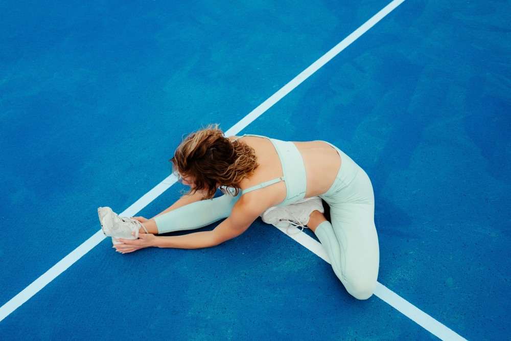 Présentation d'une photo d'une sportive effectuant des étirements pour crampes douleur au mollet droit causes