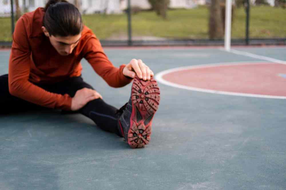 Présentation d'une photo d'un jeune homme sportif étirant son mollet pour douleur au mollet causes