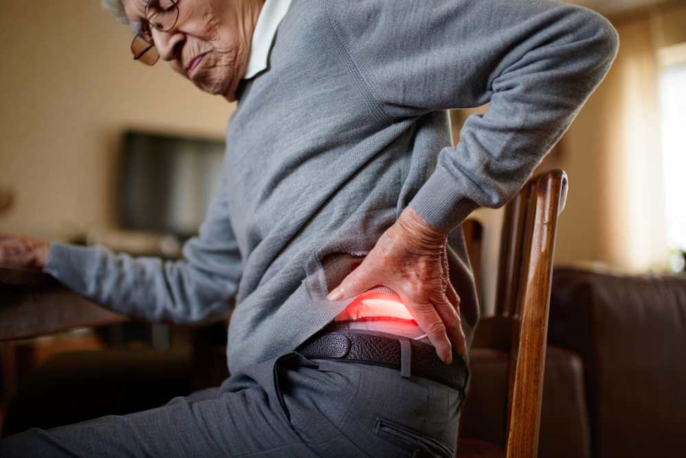 Présentation d'un homme habillé en gris souffrant de la hanche gauche pour combien de temps dure une tendinite de la hanche