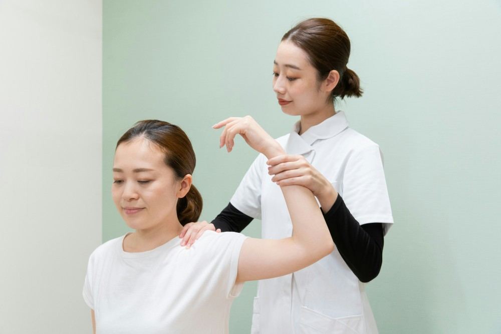 Femme examinée par kinésithérapeute pour douleur dans l'épaule et cou