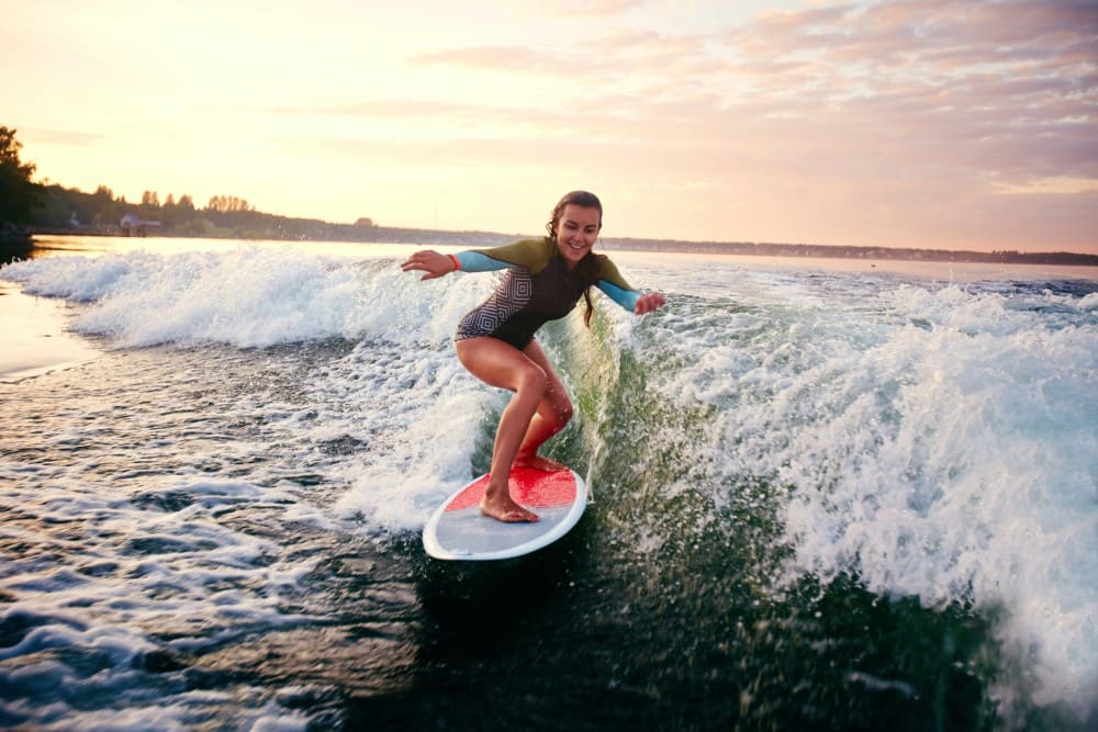Femme qui surfe sur une vague