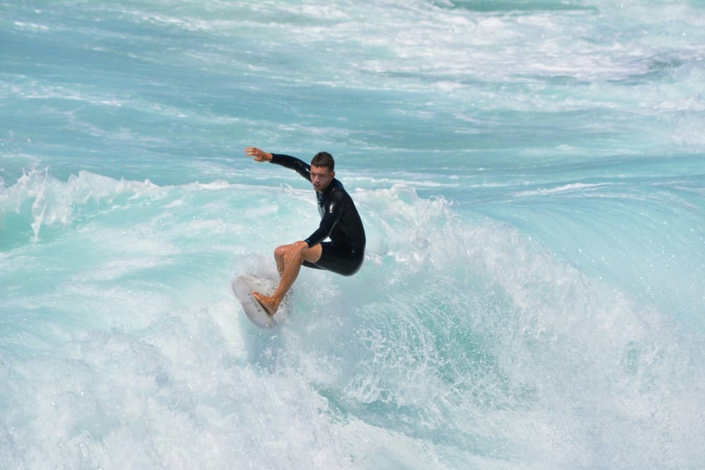 Homme en combinaison surfant sur une vague