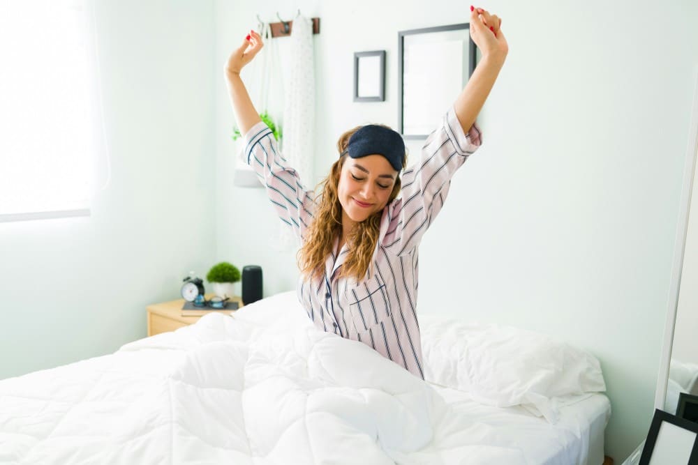 Photo d'une femme qui s'étire dans son lit