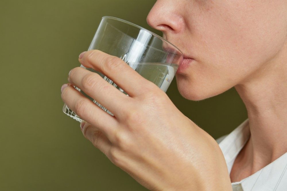 Présentation d'une femme qui boit de l'eau routine matinale