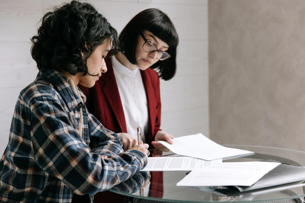 Patiente signant un contrat de mutuelle pour le remboursement de la chiropraxie