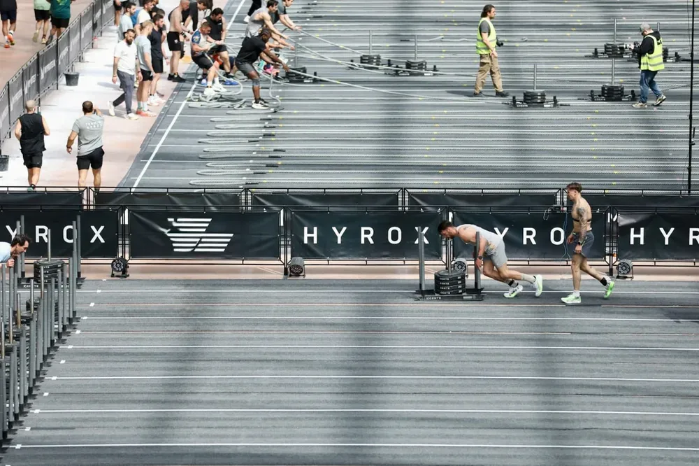 Athletes poussant des traineaux sur une piste interieure lors d une epreuve de fitness.