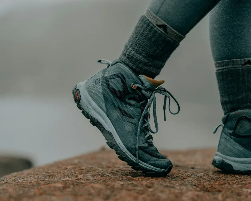 Chaussures femme grises portées sur un sol extérieur